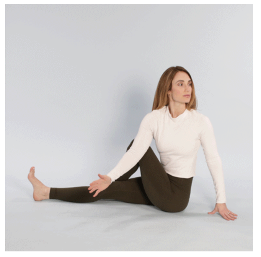 Woman performing a seated spinal stretch by turning to her side to relieve pressure on the sciatic nerve.
